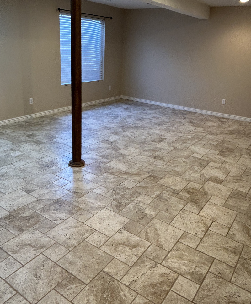 Empty basement with granite tile flooring and tan walls
